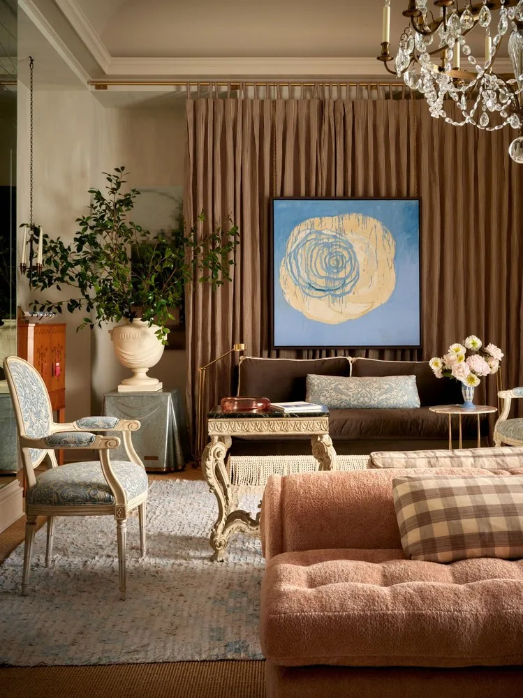 A green marble table fronts the chocolate sofa beneath the abstract rose painting